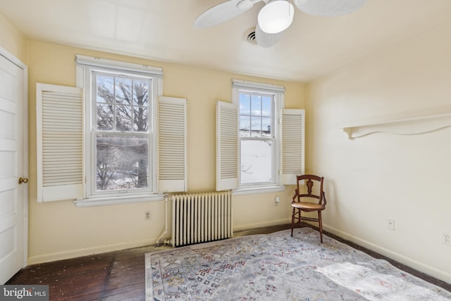 unfurnished room featuring hardwood / wood-style flooring, ceiling fan, and radiator