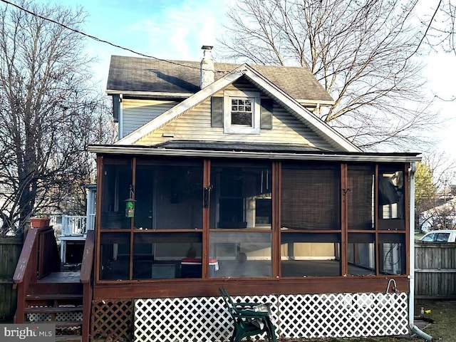 rear view of house featuring a sunroom