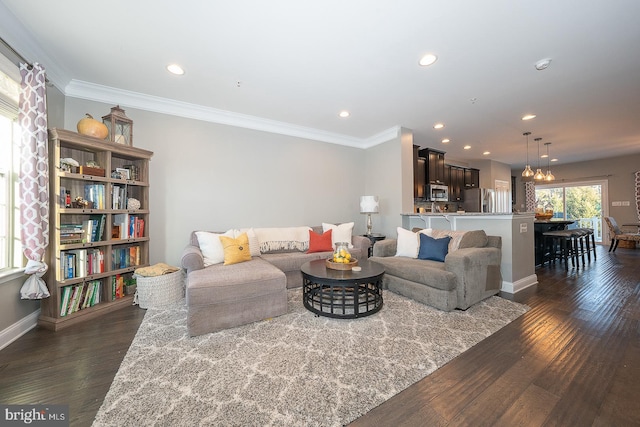 living room featuring crown molding, dark hardwood / wood-style flooring, and a notable chandelier