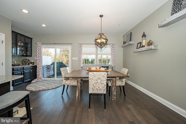 dining space featuring dark wood-type flooring and an inviting chandelier