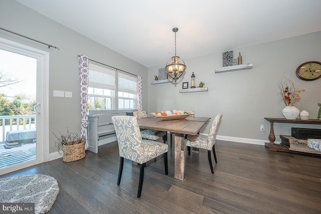 dining area with dark hardwood / wood-style flooring, an inviting chandelier, and plenty of natural light