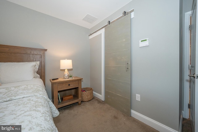 carpeted bedroom with a barn door