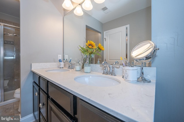 bathroom featuring tile patterned flooring, vanity, toilet, and a shower with shower door