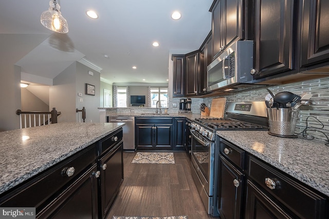 kitchen featuring sink, hanging light fixtures, dark hardwood / wood-style flooring, decorative backsplash, and appliances with stainless steel finishes