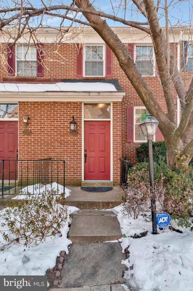 snow covered property entrance with central AC