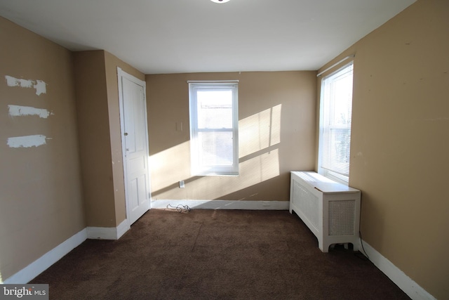 carpeted spare room featuring radiator