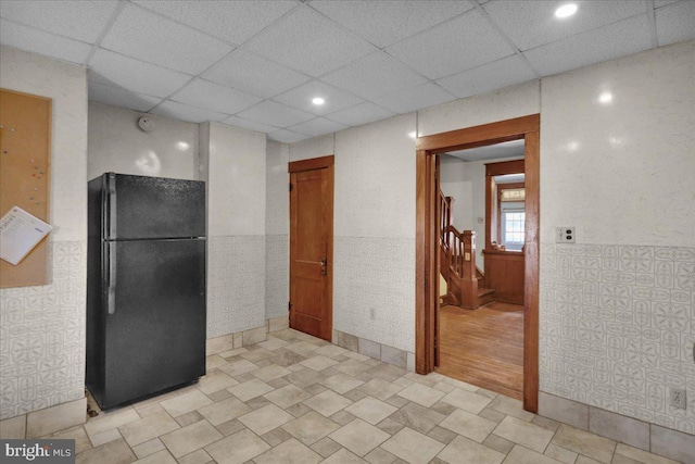 kitchen with a drop ceiling and black fridge