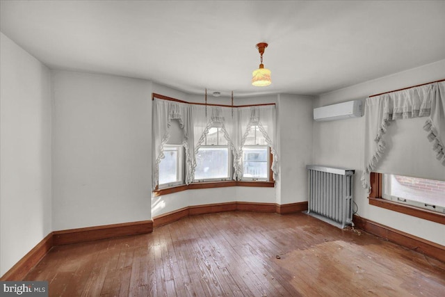 unfurnished dining area with radiator heating unit, wood-type flooring, and an AC wall unit