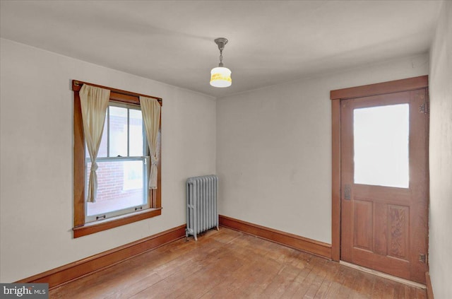 empty room with radiator and light wood-type flooring