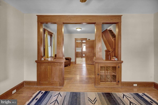 interior space featuring light hardwood / wood-style flooring and decorative columns