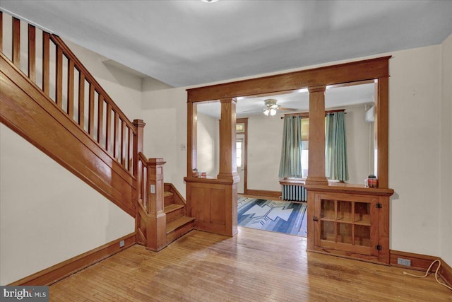 entryway with light hardwood / wood-style flooring, ceiling fan, and ornate columns