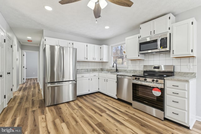 kitchen featuring tasteful backsplash, white cabinetry, and appliances with stainless steel finishes