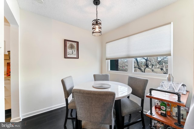 dining room featuring dark hardwood / wood-style flooring and a textured ceiling