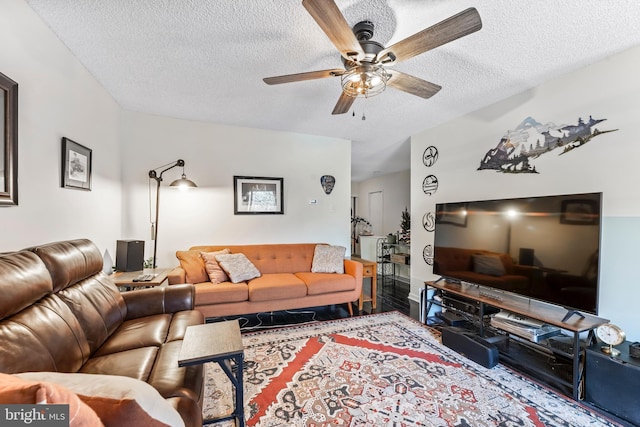 living room with ceiling fan, a textured ceiling, and hardwood / wood-style flooring