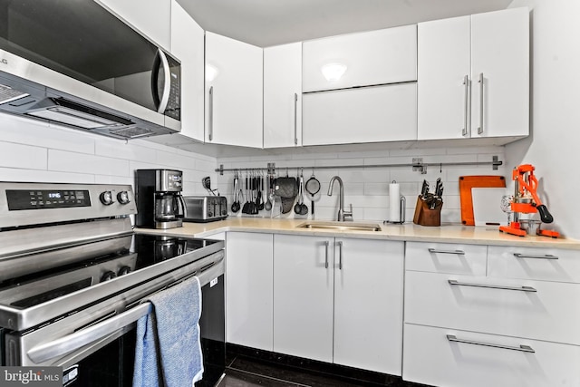 kitchen featuring appliances with stainless steel finishes, backsplash, and white cabinetry