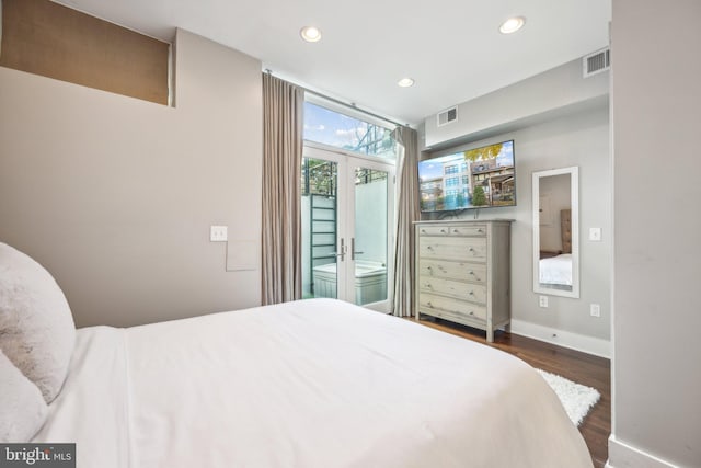 bedroom featuring french doors, connected bathroom, and dark hardwood / wood-style floors