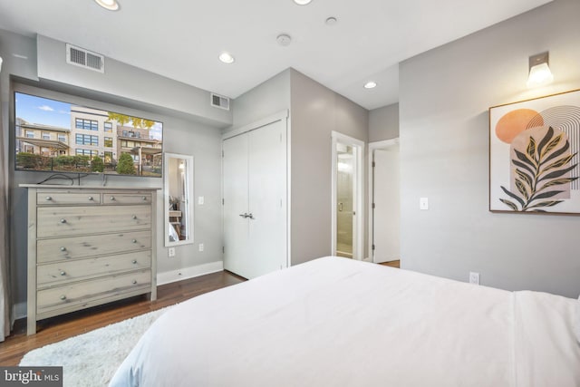 bedroom featuring connected bathroom, a closet, and dark wood-type flooring