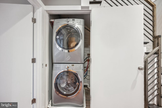 clothes washing area with stacked washing maching and dryer