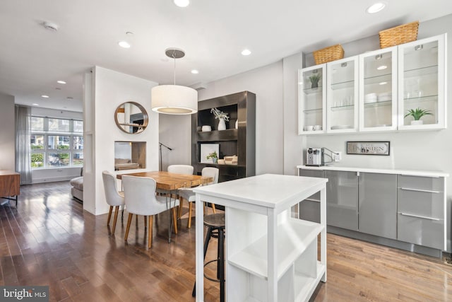 kitchen featuring white cabinets, pendant lighting, and hardwood / wood-style flooring