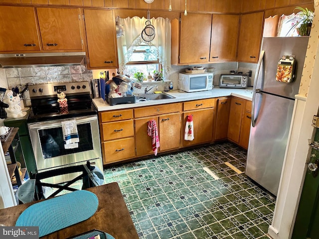 kitchen with decorative backsplash, sink, and appliances with stainless steel finishes