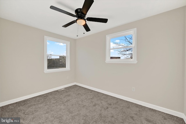 carpeted empty room featuring ceiling fan and a healthy amount of sunlight