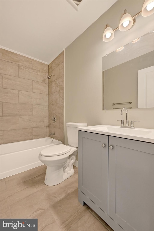 full bathroom with vanity, tiled shower / bath, and toilet