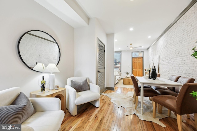 dining room with brick wall and light wood-type flooring