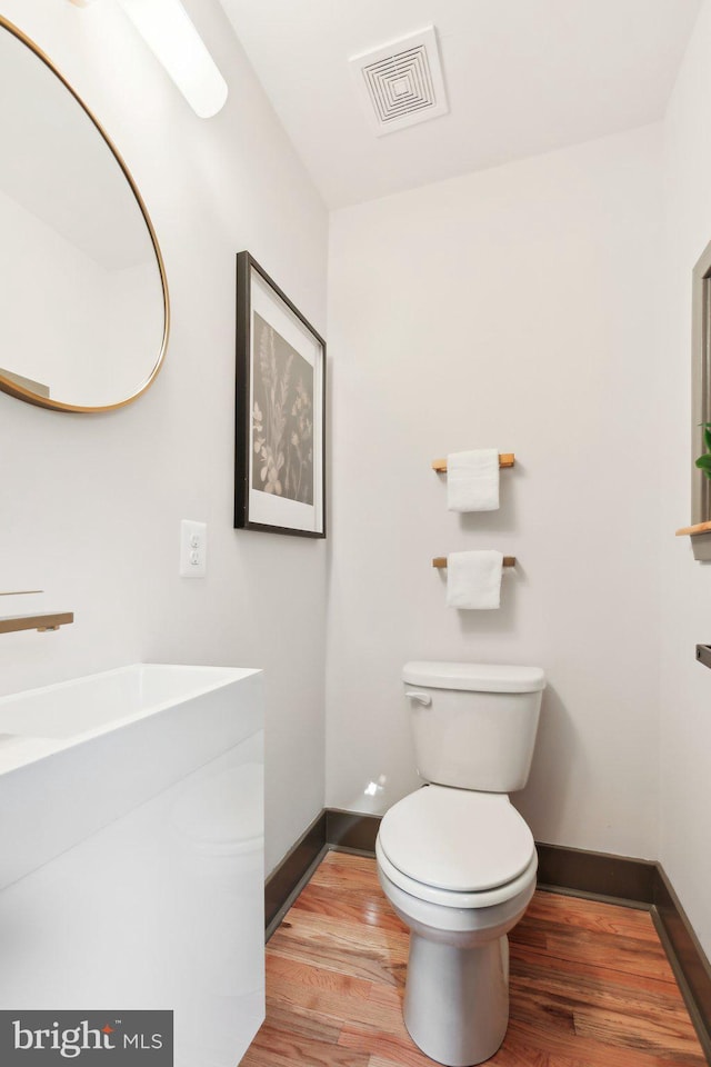 bathroom with hardwood / wood-style floors and toilet