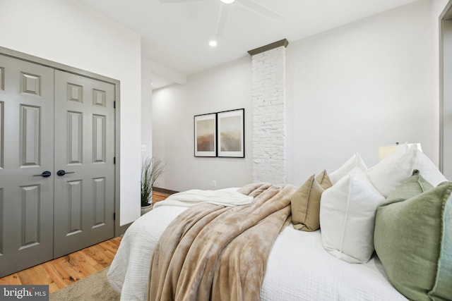 bedroom with hardwood / wood-style floors, ceiling fan, and a closet