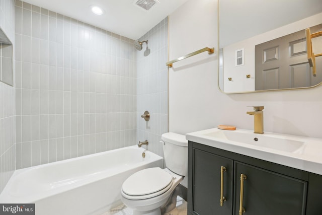 full bathroom featuring vanity, tiled shower / bath, and toilet