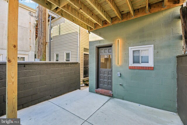 view of exterior entry with a patio area