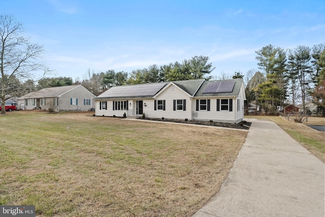 single story home featuring a front yard and solar panels