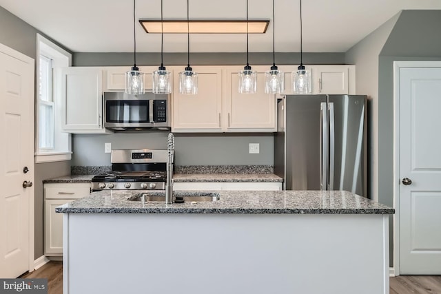 kitchen with stone counters, sink, white cabinets, and stainless steel appliances