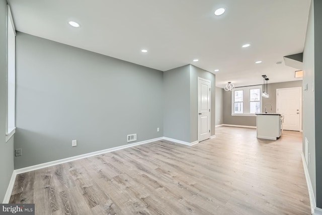 unfurnished living room featuring light wood-type flooring and sink