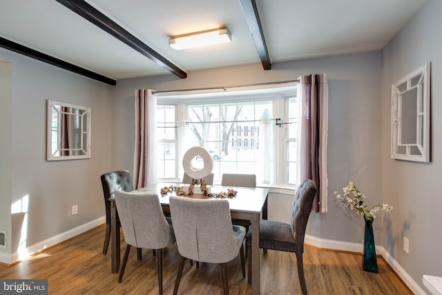 dining room with beam ceiling and hardwood / wood-style floors