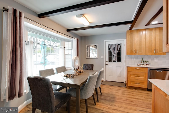 dining area featuring beam ceiling and light hardwood / wood-style floors