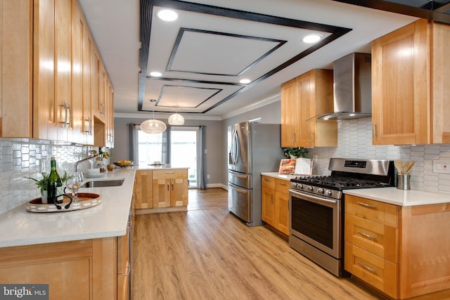 kitchen with crown molding, wall chimney exhaust hood, light wood-type flooring, and appliances with stainless steel finishes