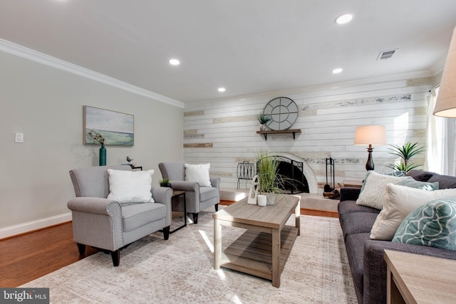 living room with light wood-type flooring, crown molding, and wooden walls