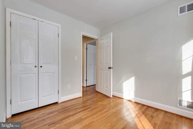 unfurnished bedroom with a closet and light hardwood / wood-style floors