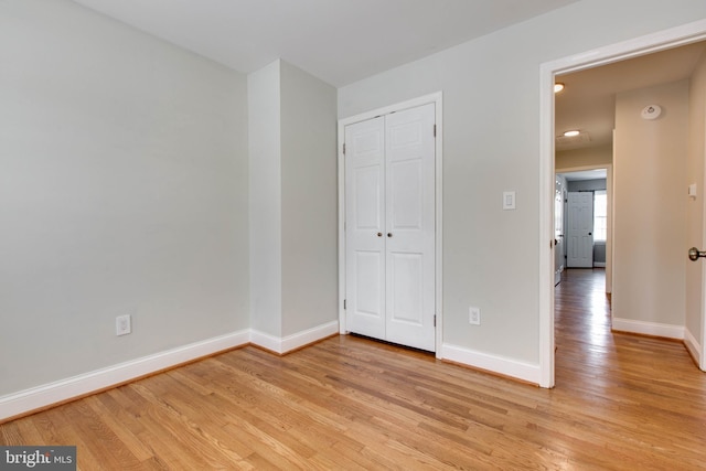 unfurnished bedroom featuring a closet and light hardwood / wood-style floors