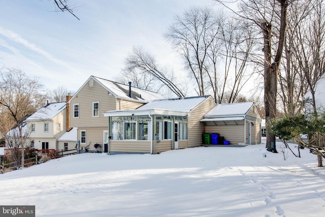 view of snow covered back of property