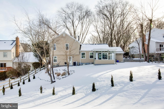 snow covered rear of property with central AC unit