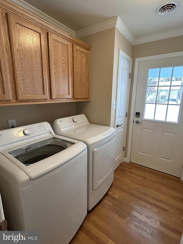 1689 Gerrardstown Rd, Gerrardstown, WV 25420 - clothes washing area featuring crown molding, cabinets, separate washer and dryer, and wood-type flooring