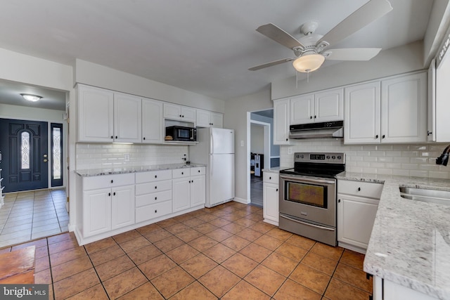 kitchen featuring backsplash, electric stove, light tile patterned floors, white refrigerator, and white cabinetry