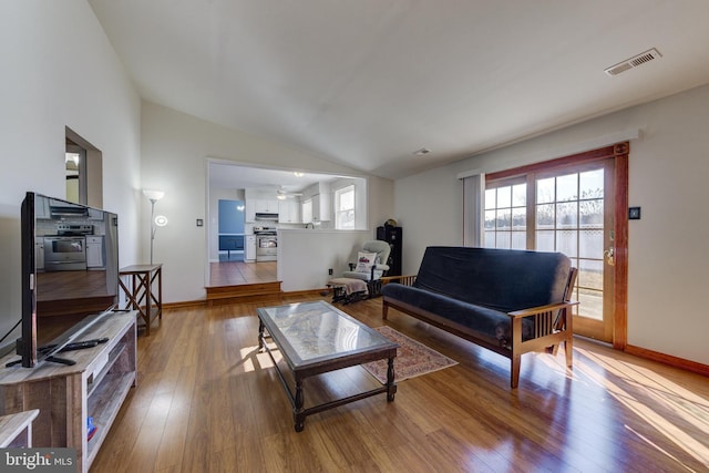 living room featuring light wood-type flooring and vaulted ceiling