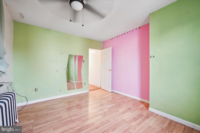 unfurnished bedroom featuring ceiling fan, radiator, and light hardwood / wood-style floors