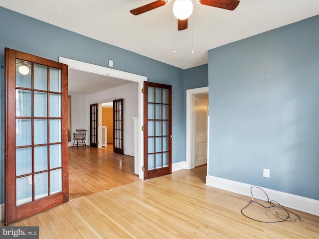 unfurnished room featuring french doors, light wood-type flooring, and ceiling fan