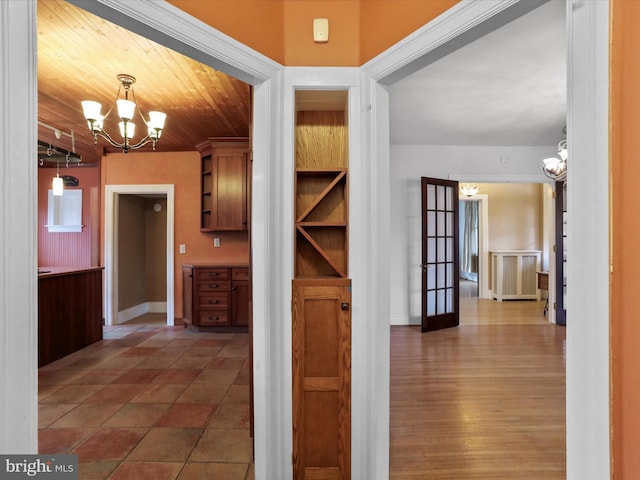 hall featuring a notable chandelier and wooden ceiling