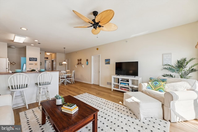 living room with ceiling fan and light hardwood / wood-style floors