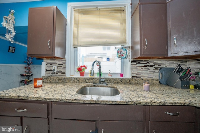 kitchen featuring dark brown cabinetry, sink, and tasteful backsplash